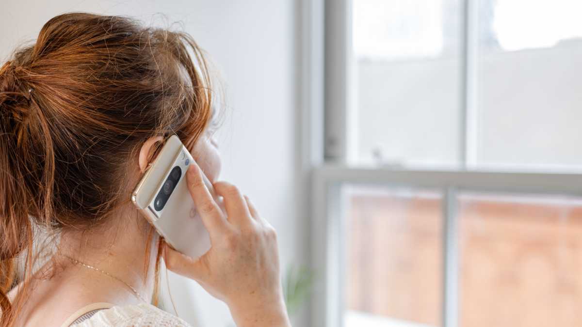 A woman holding the Google Pixel 8 Pro up to her ear