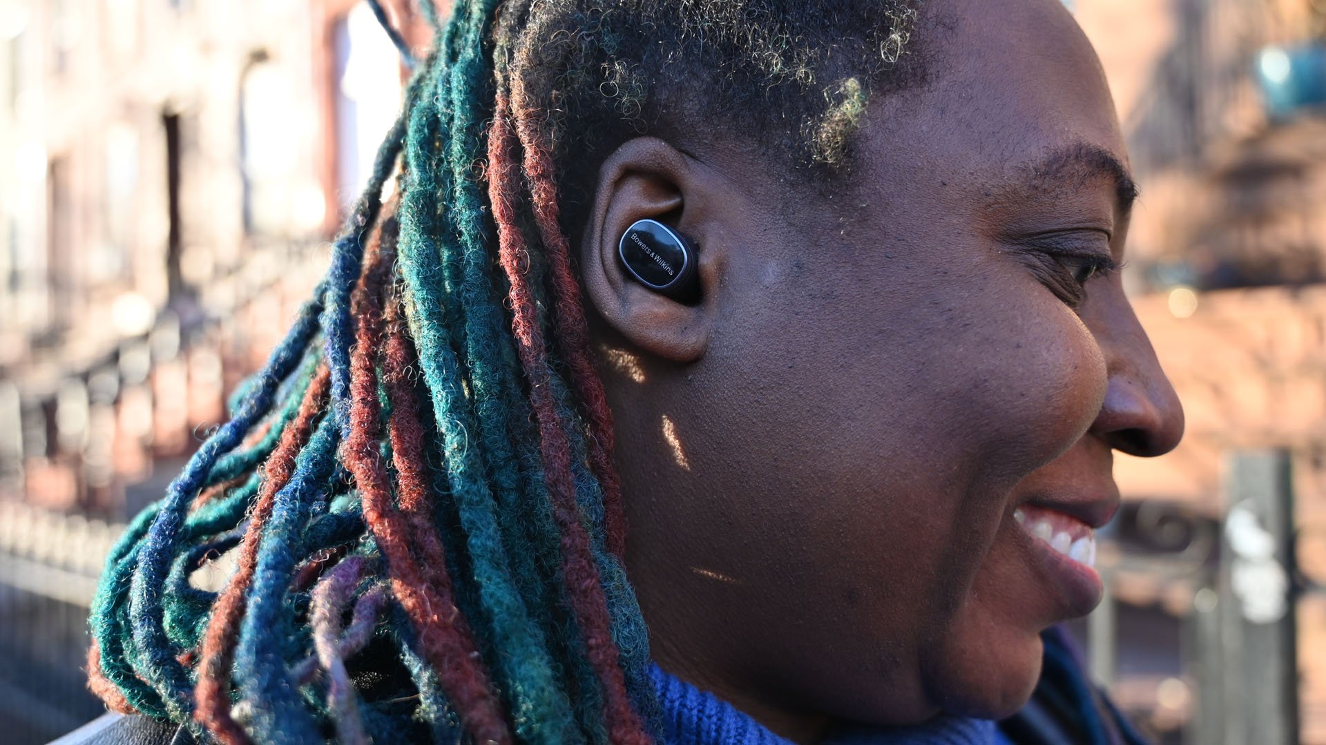 Shot of African-American woman wearing Bowers & Wilkins Pi8 earbuds 