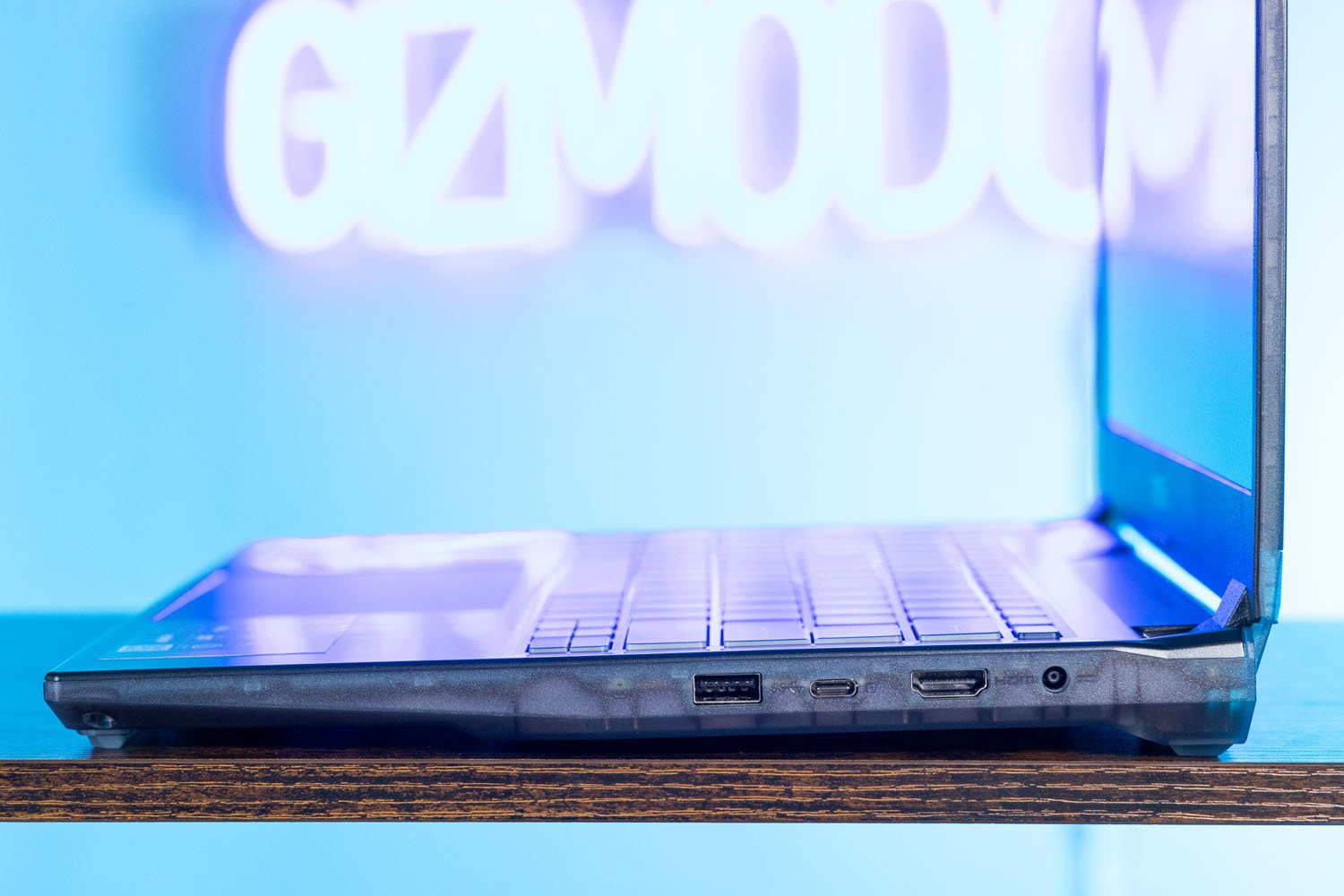 Side-shot of the MSI Cyborg 14 showing ports in front of neon Gizmodo sign