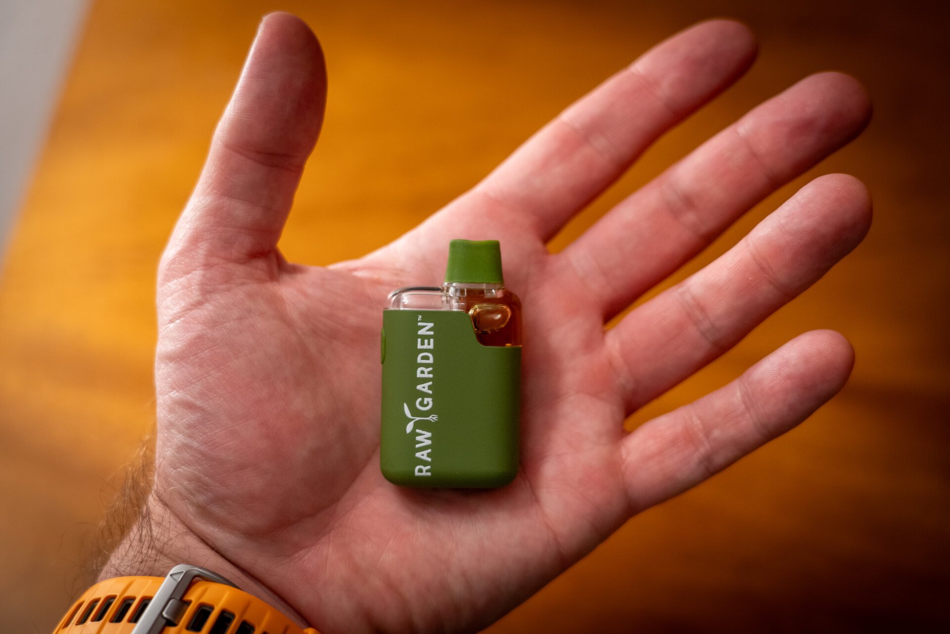 An image of the vape in the palm of a man's hand.