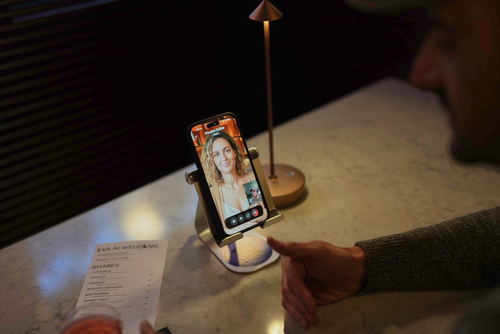 A man talking to a phone screen showing an AI-generated woman