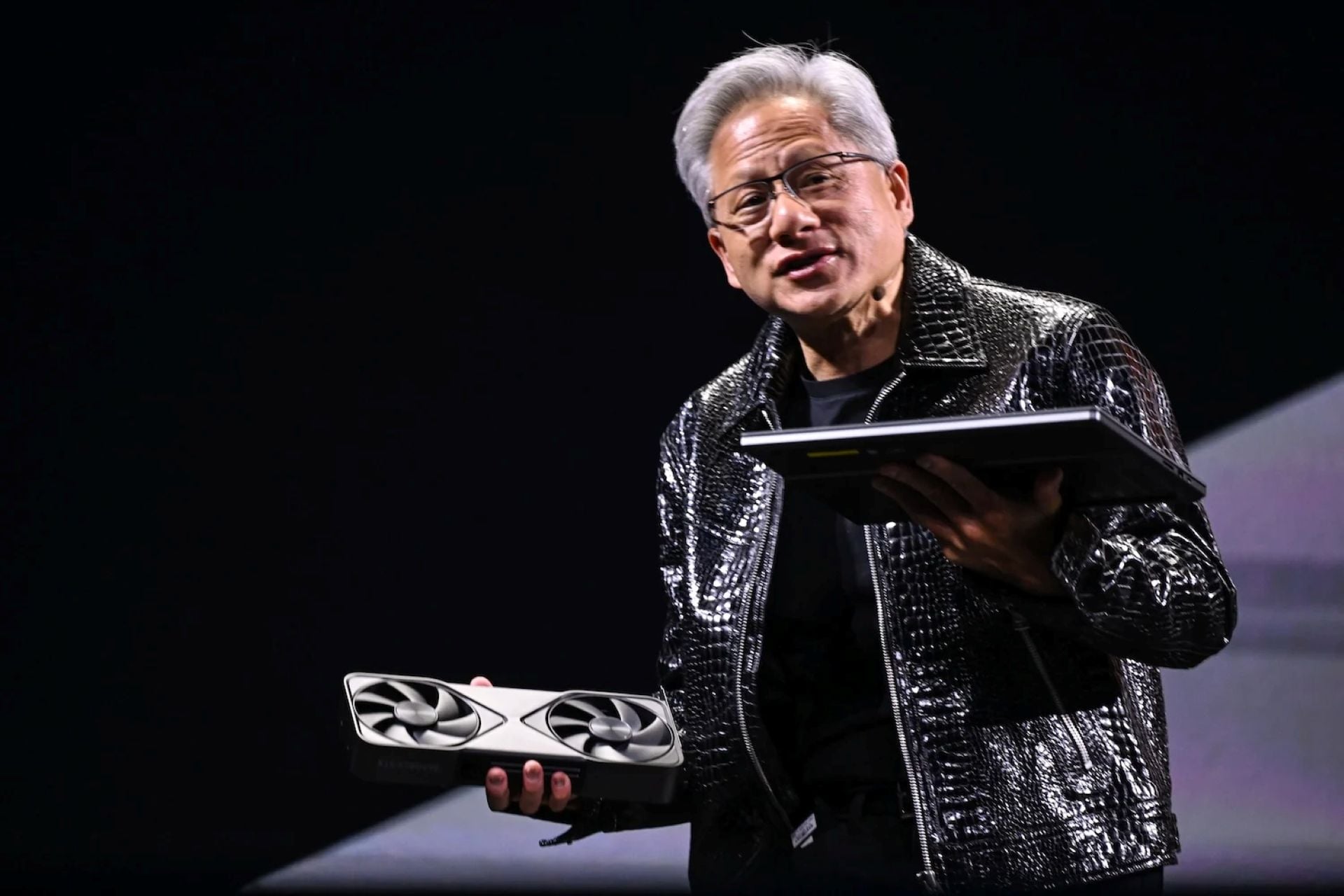 Nvidia Ceo Jensen Huang holidng a laptop and Rtx 50 Series Gpu