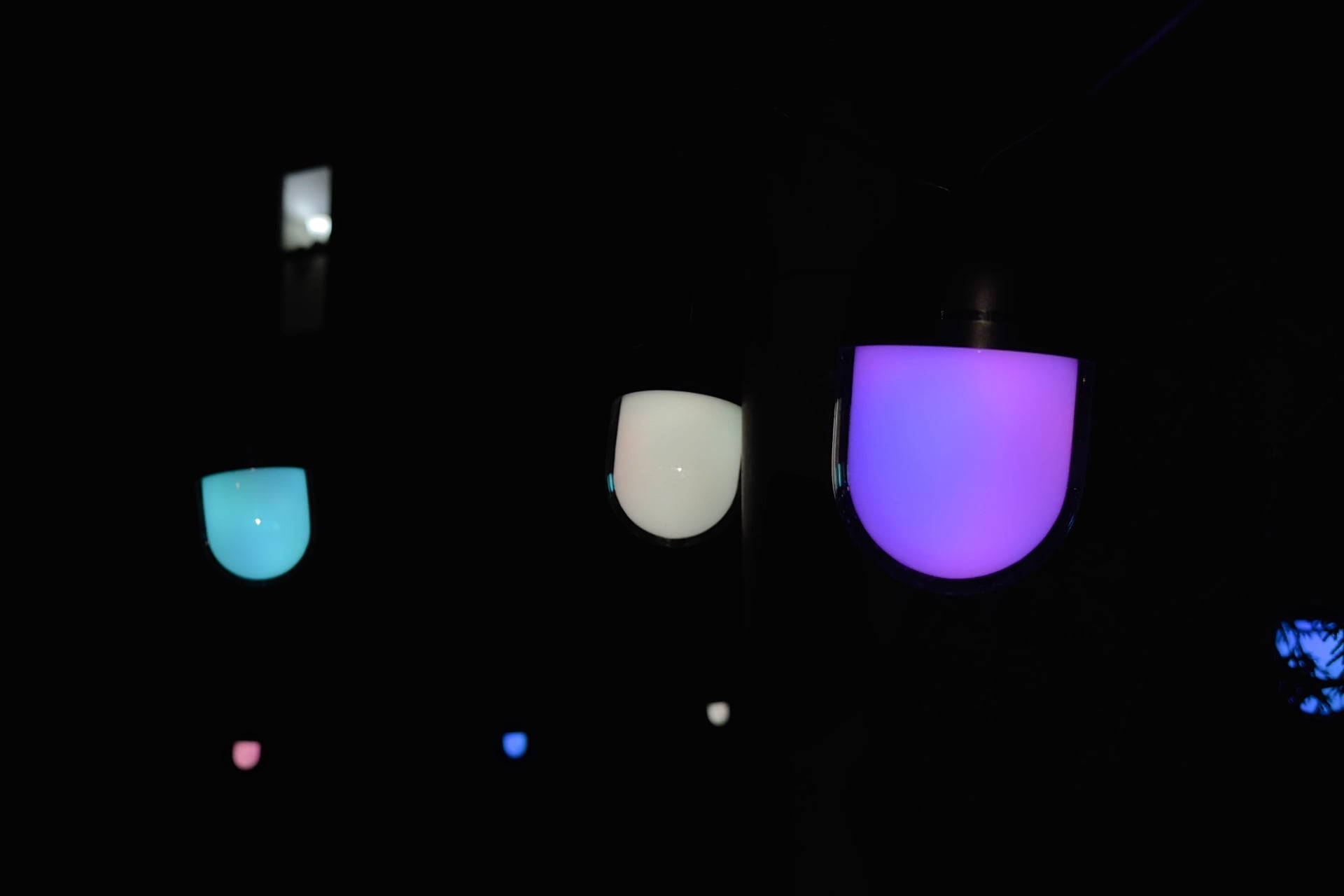 Three Govee Outdoor Chromatic String Lights bulbs showing multiple colors.
