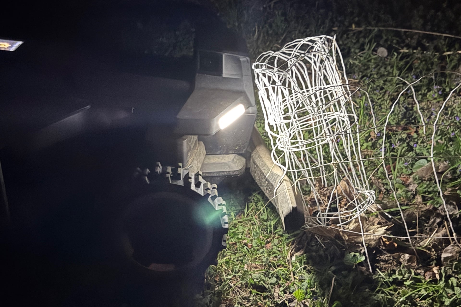 Navimow X430 stuck on a garden fence while mowing at night.