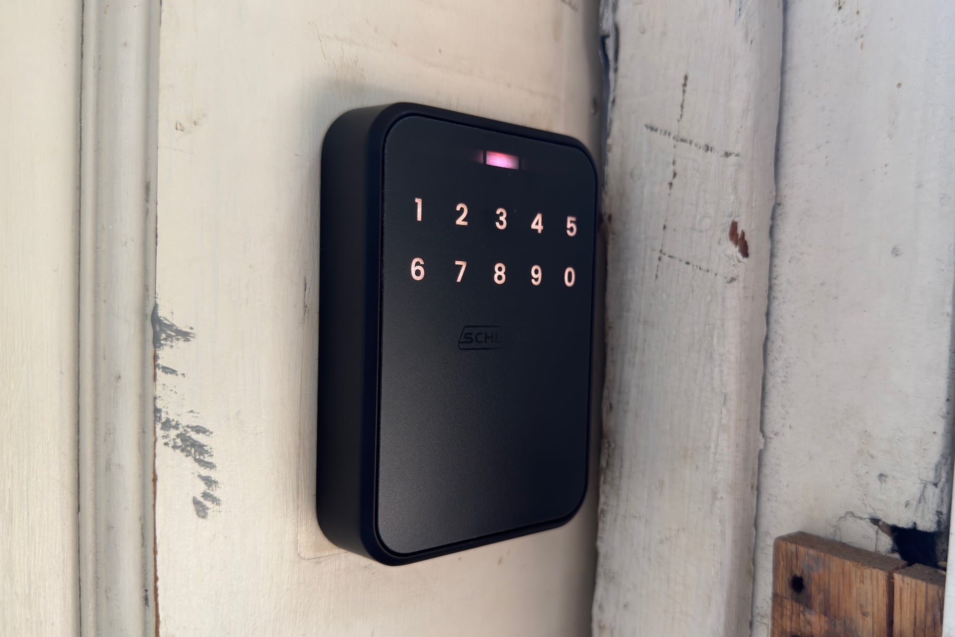 Schlage Sense Pro exterior portion shown with the keypad digits lit up. The numbers appear in two rows of five digits.