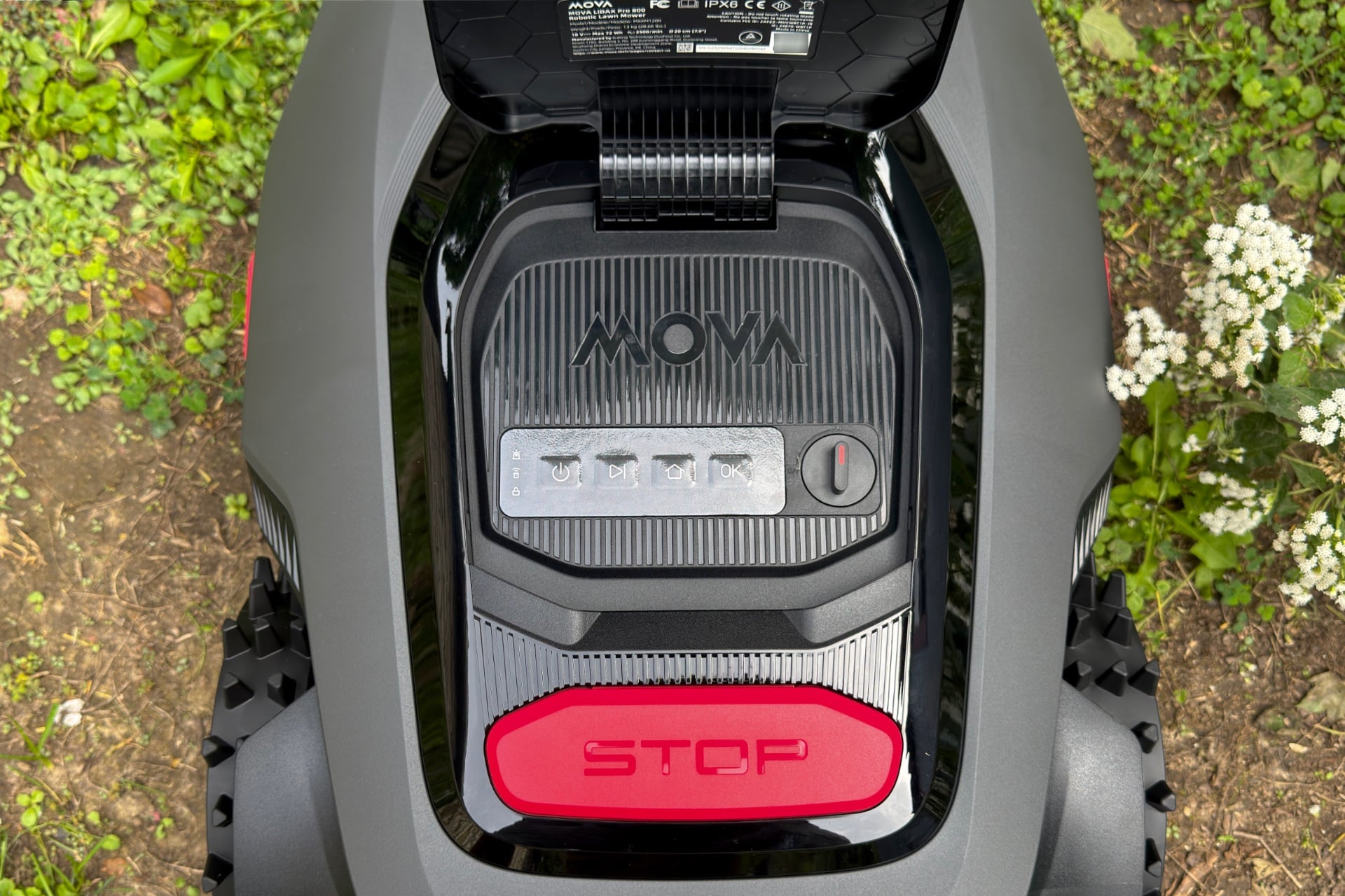 Close-up showing the Mova LiDAX Pro 800 with its upper hood raised, revealing the control buttons and on/off switching knob. From left to right: Power, next, home, and OK. Below all of this is a large red button labeled "STOP"