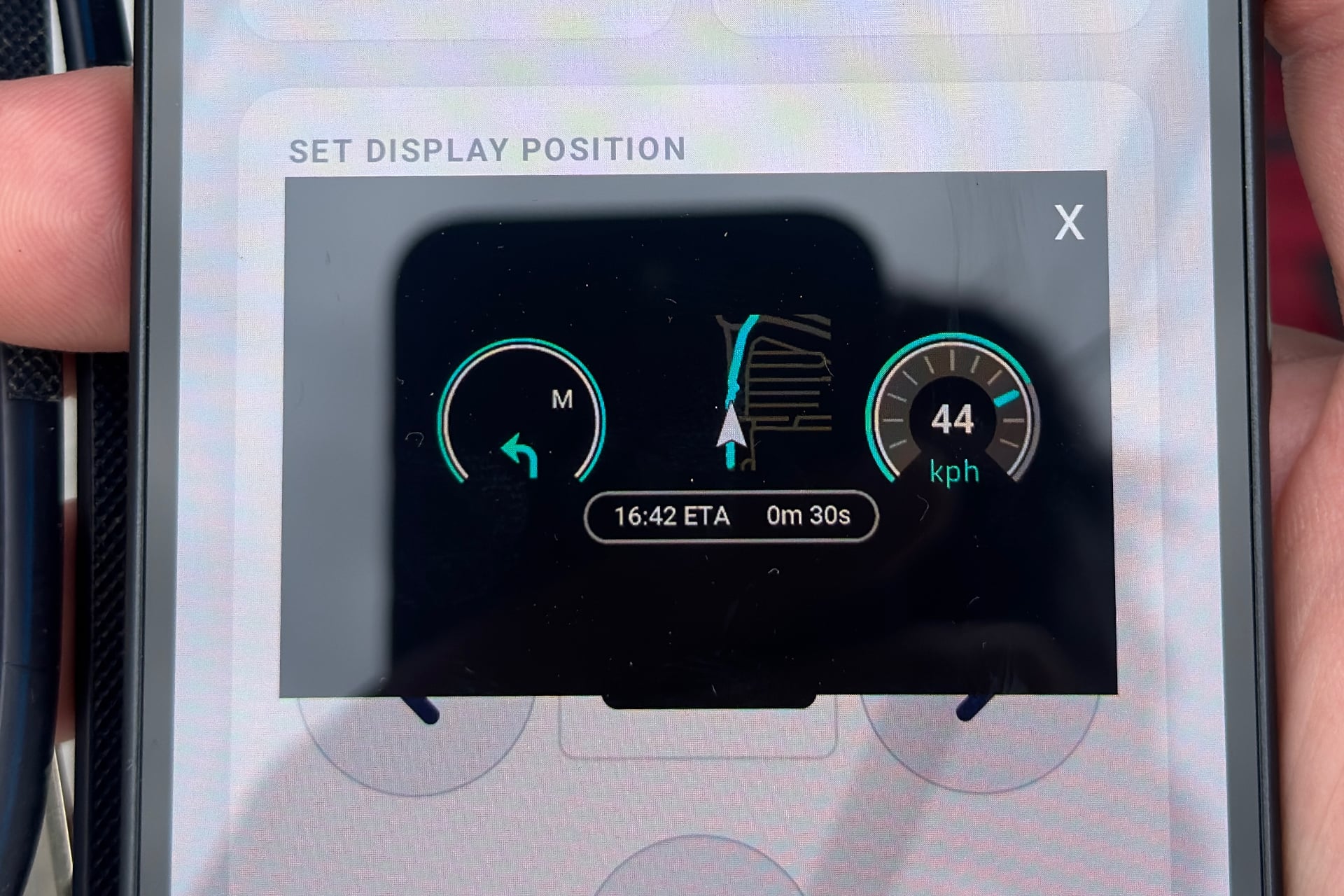 Picture of a smartphone screen showing the N Plus Volkswagen E Bike HUD layout as I was seeing it. It has two circular gauges straddling a GPS map.